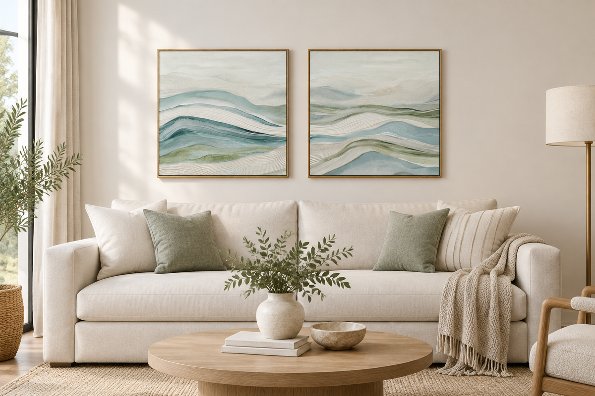Par de quadros abstratos em tons azul, verde e marfim, expostos sobre um sofá numa sala moderna